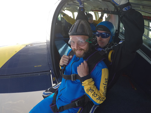 Gaz sat on the edge of a plane about to Skydive